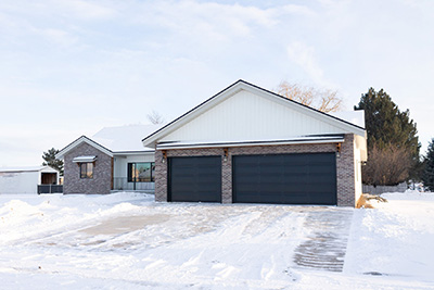 Custom home exterior garage door that matches the front door color